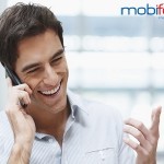 Laughing young guy enjoying a conversation over the cellphone